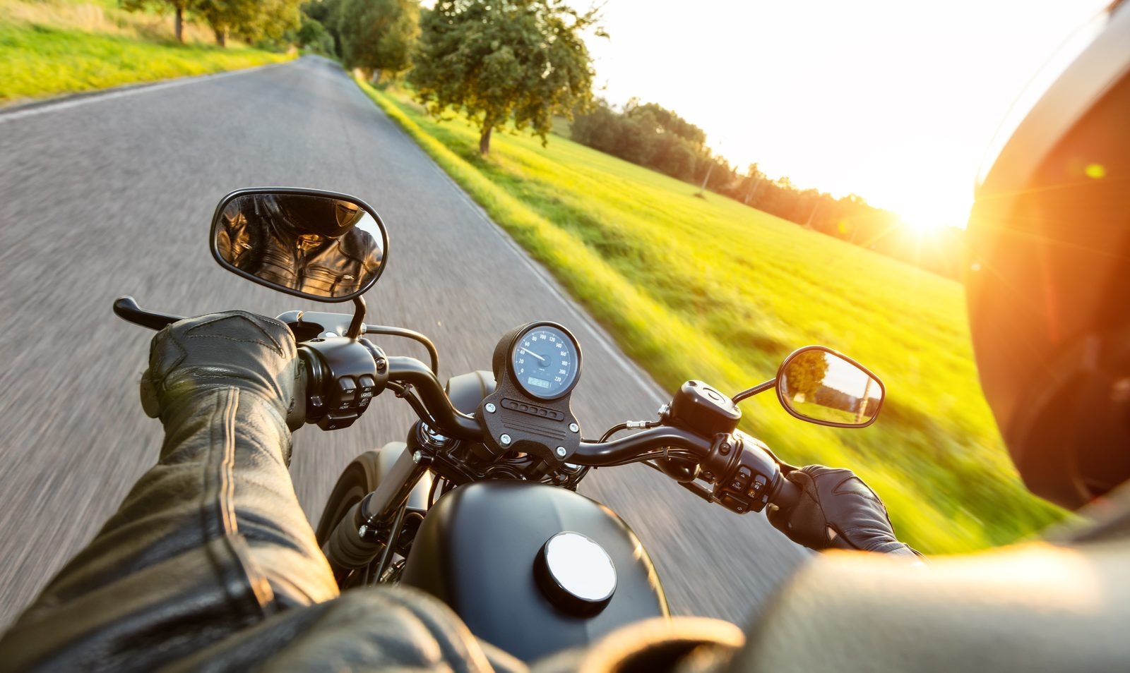 A lone rider chatting to a group at a roadside café, helmets scattered across the table