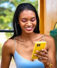A woman smiling at her phone during a video chat