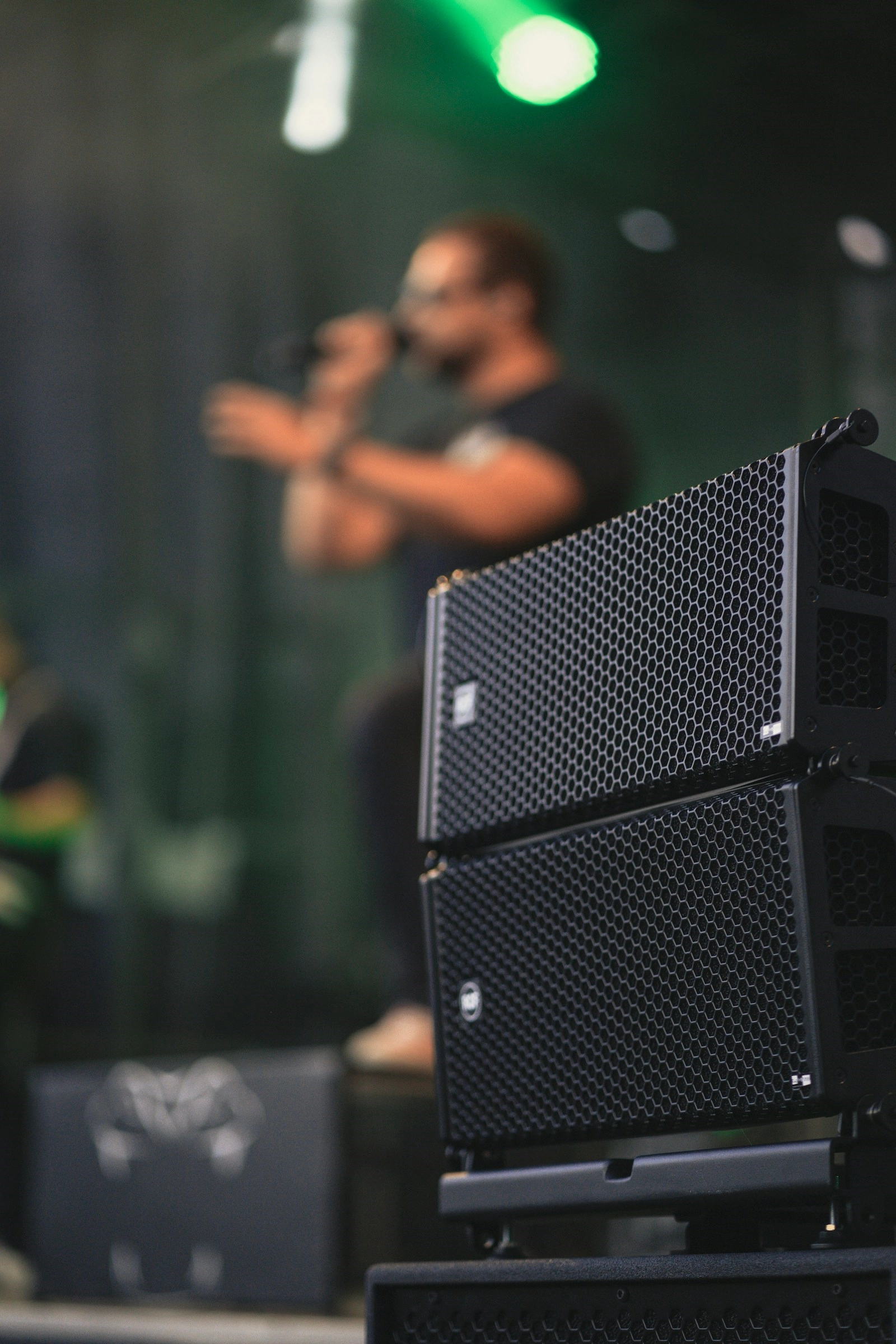 An MC on stage behind a stack of speakers