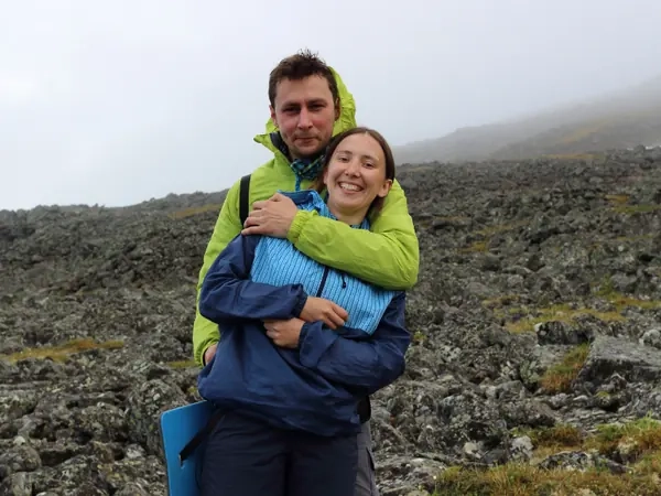 A couple holding each other on a misty hilltop in walking gear