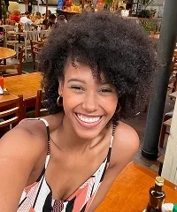 A smiling woman taking a selfie in a busy restaurant