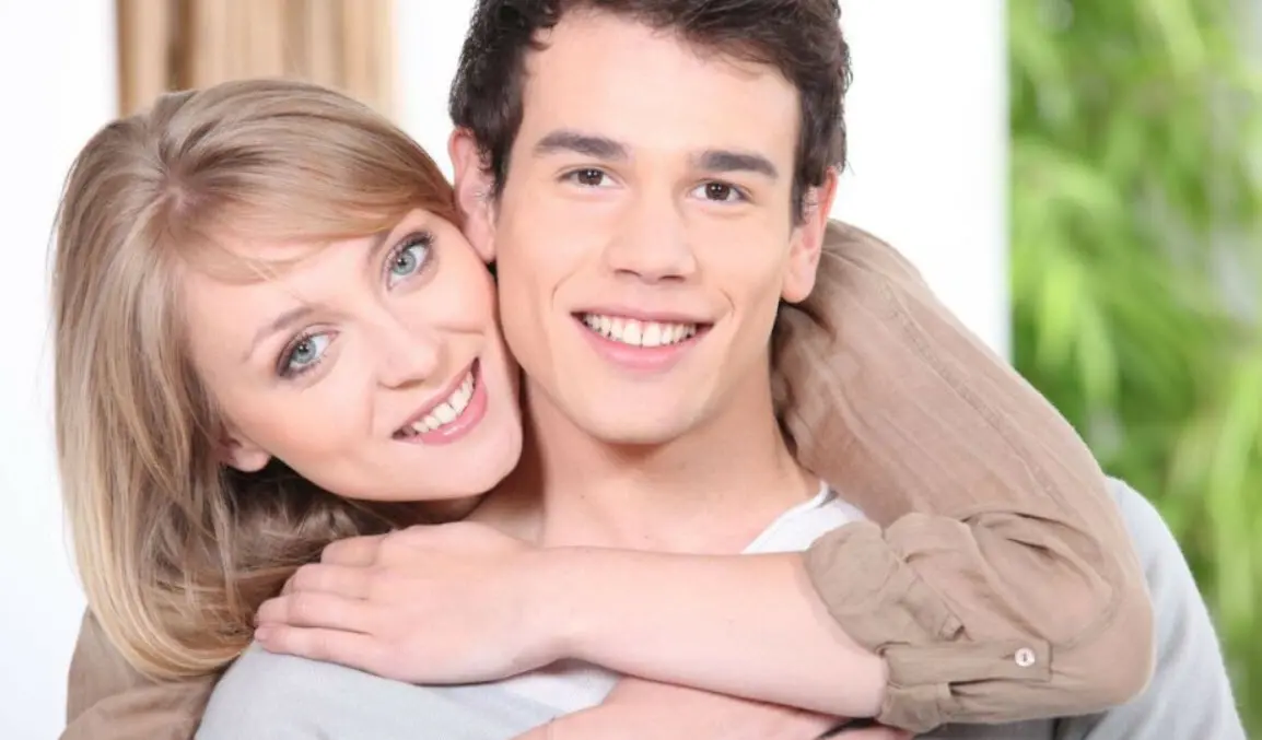 Cómo conocer maduras en tu zona sin pagar: pareja sonriente abrazada en casa