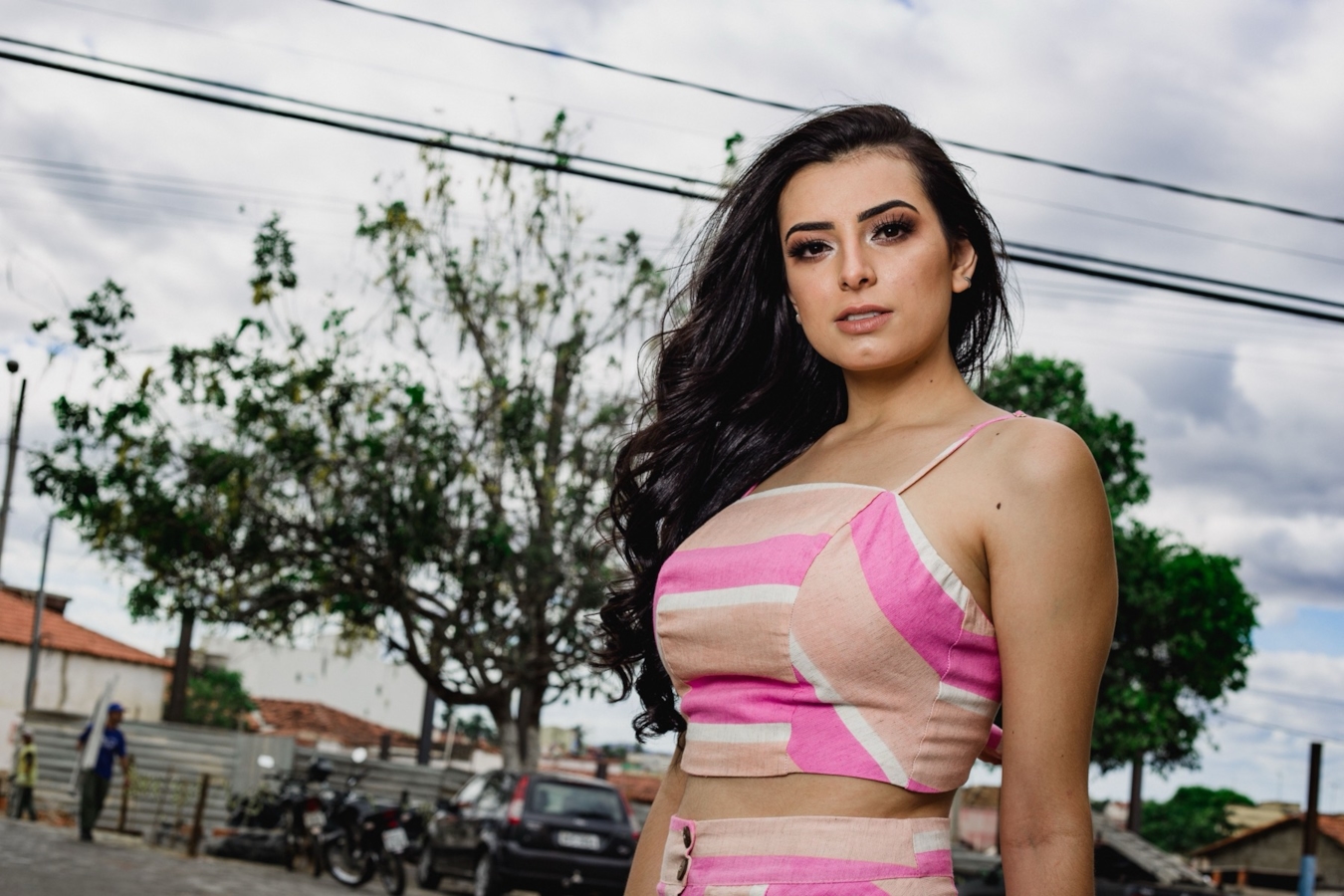 Illustrative stock photo of a woman standing outdoors on a city street. Does not depict real members.\