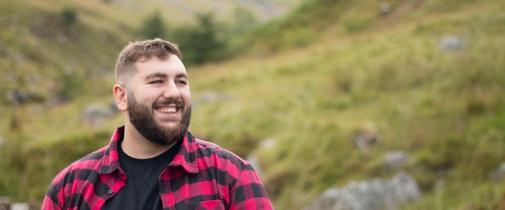 A chubby man smiling outdoors