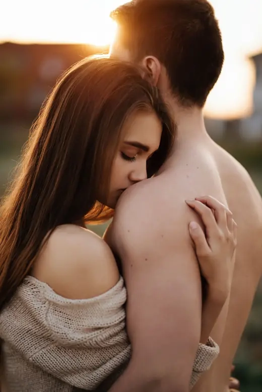 A couple embracing closely, lit by warm afternoon light