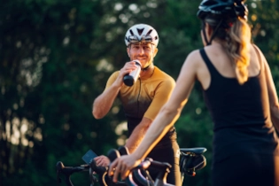 Couple taking a break from cycling and drinking water