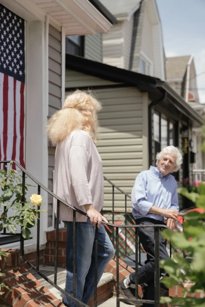 Illustrative photo, not an actual member. A couple on a front porch with an American flag.