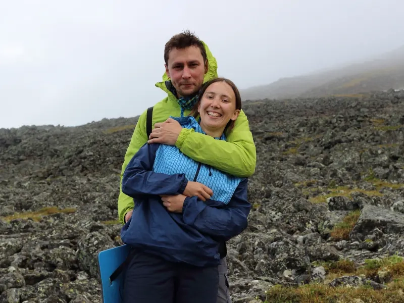 A couple holding each other on a misty hilltop in walking gear