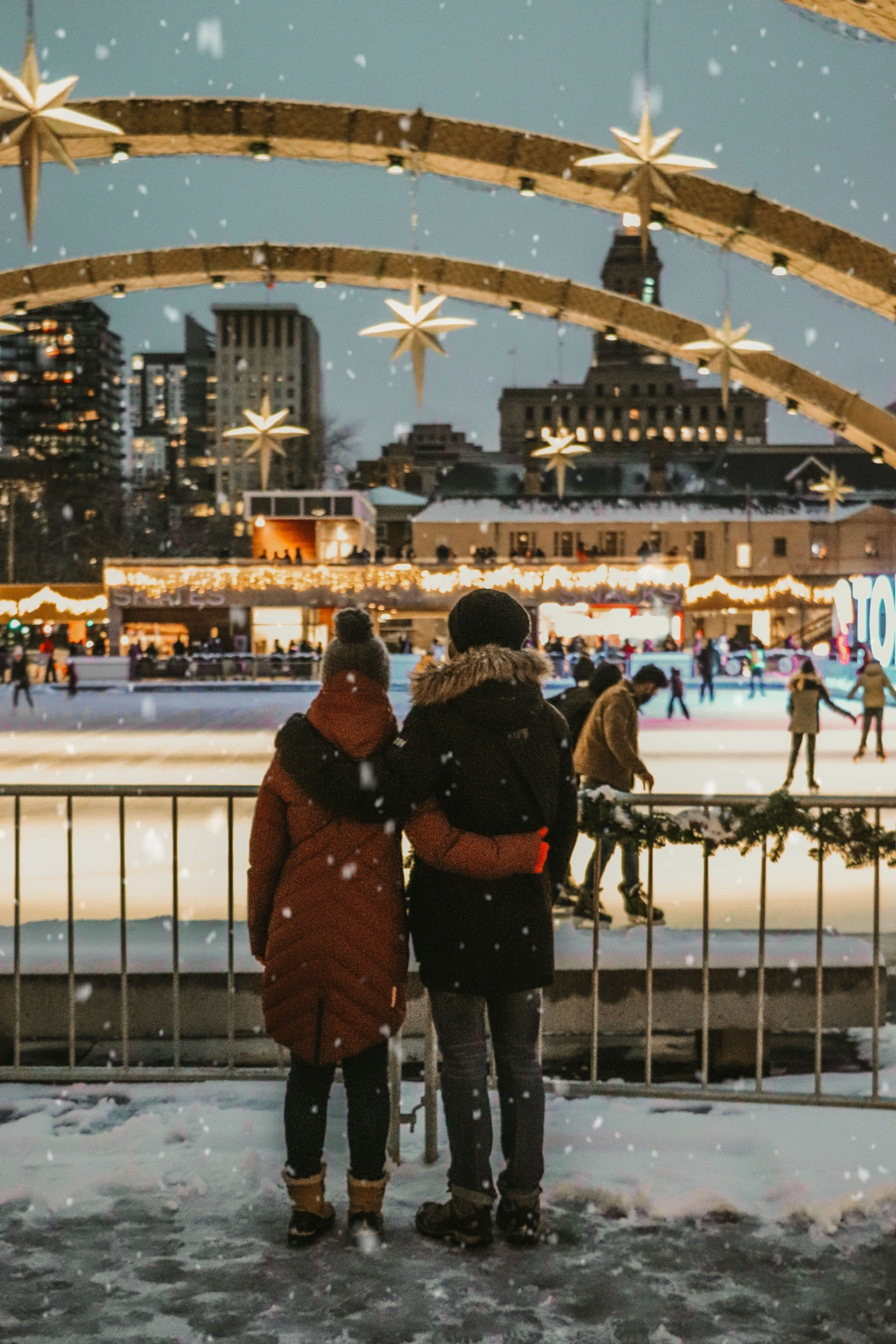 Couple côte à côte dans un marché d'hiver illuminé