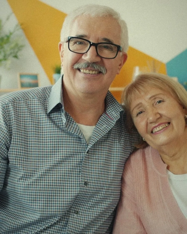 Smiling older couple with white hair on a sofa