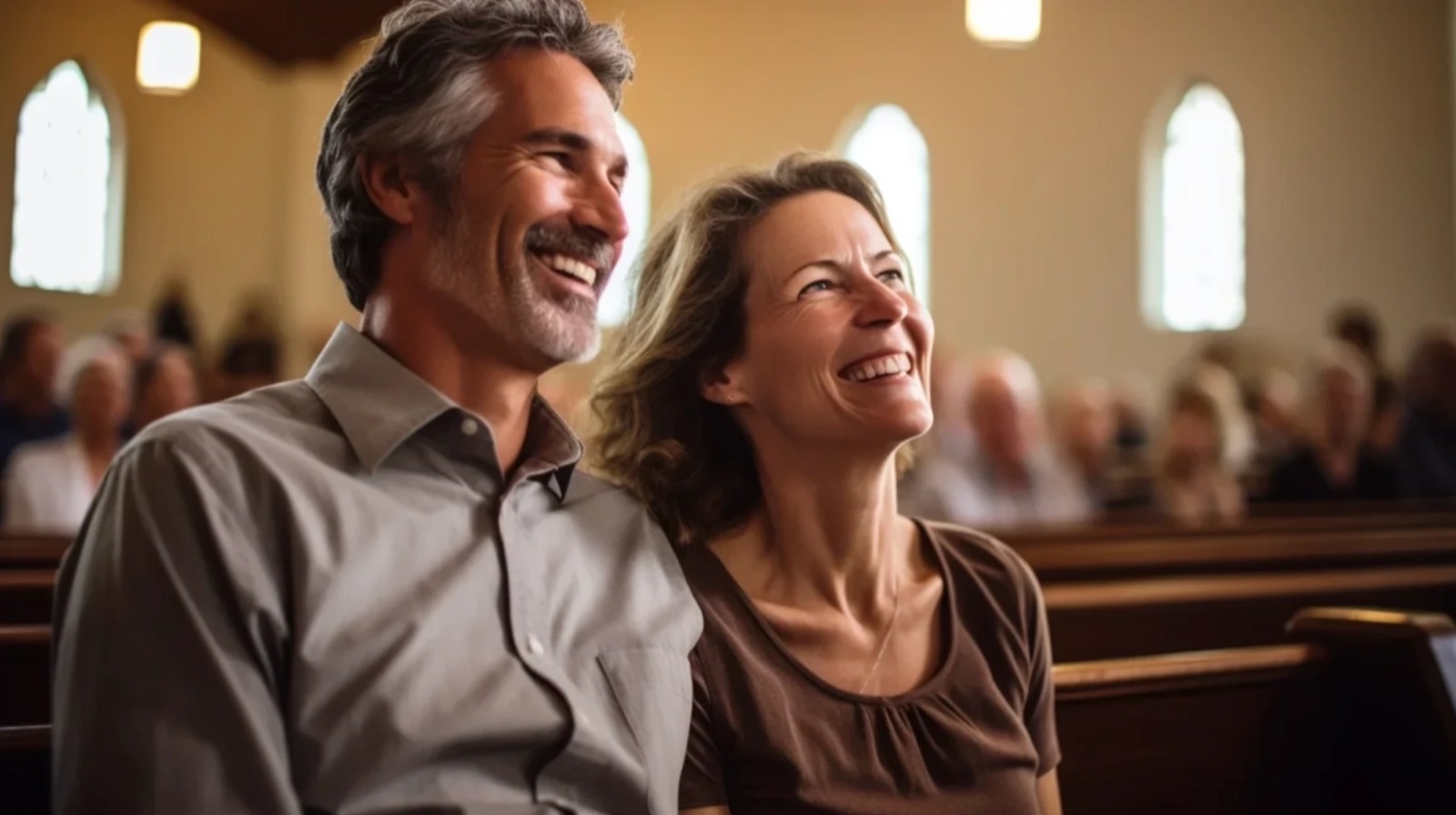 A smiling man and woman sitting together in a church pew