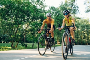 Couple riding bikes together, man smiling admiringly at woman