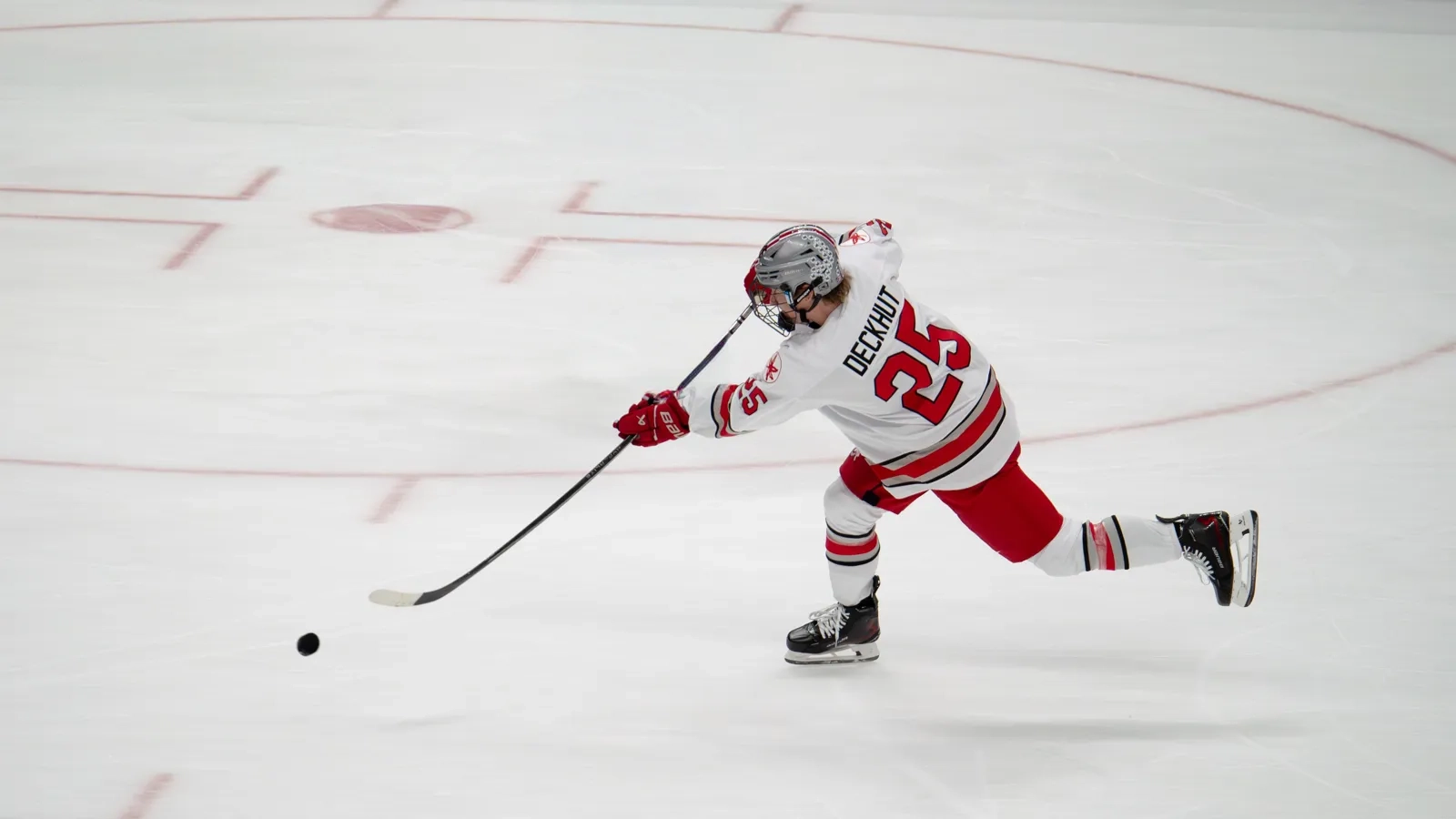 A skater winding up for a slap shot during a game