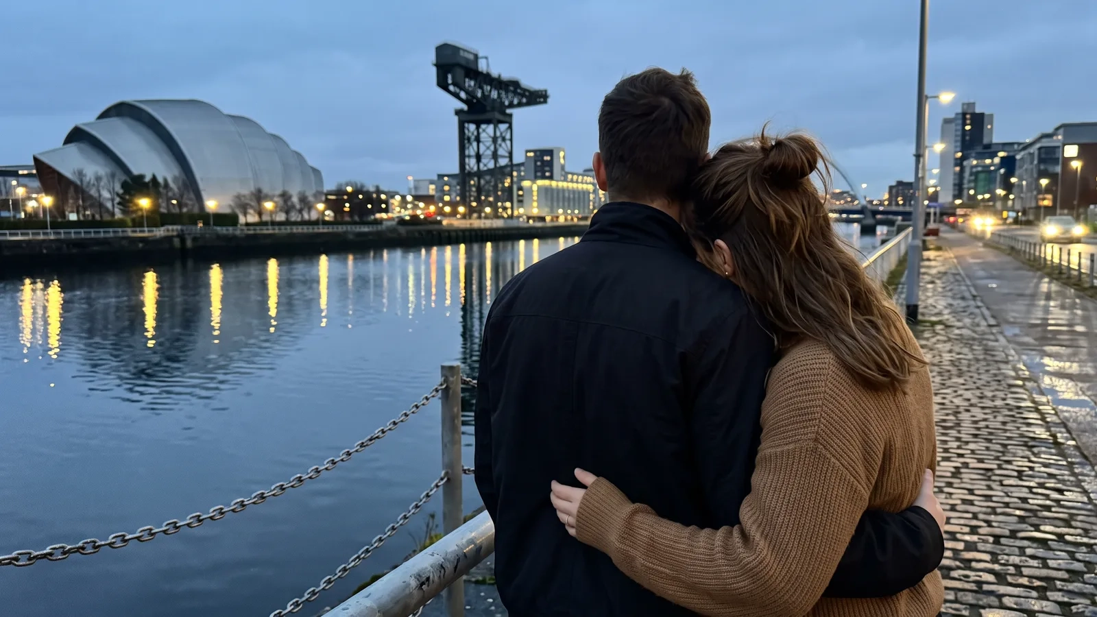 A couple stands close together at a railing beside the River Clyde in Glasgow at blue hour, city lights reflected in the water (AI-generated image)