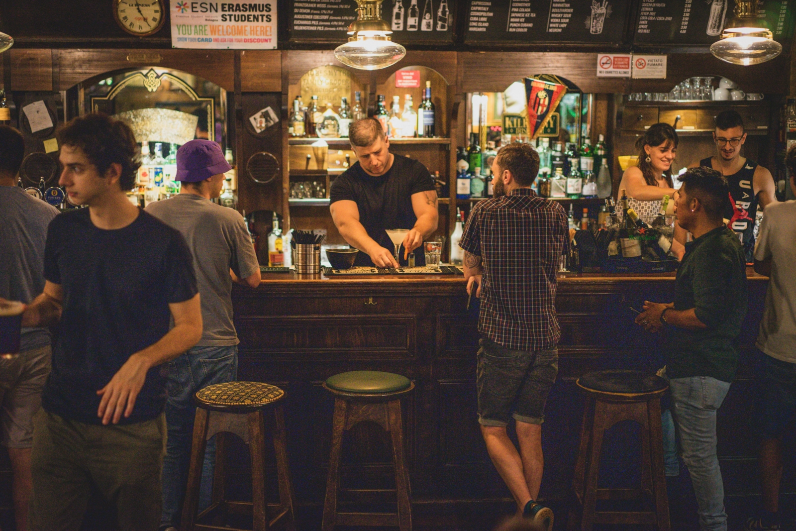 Interior de un bar con gente en la barra.