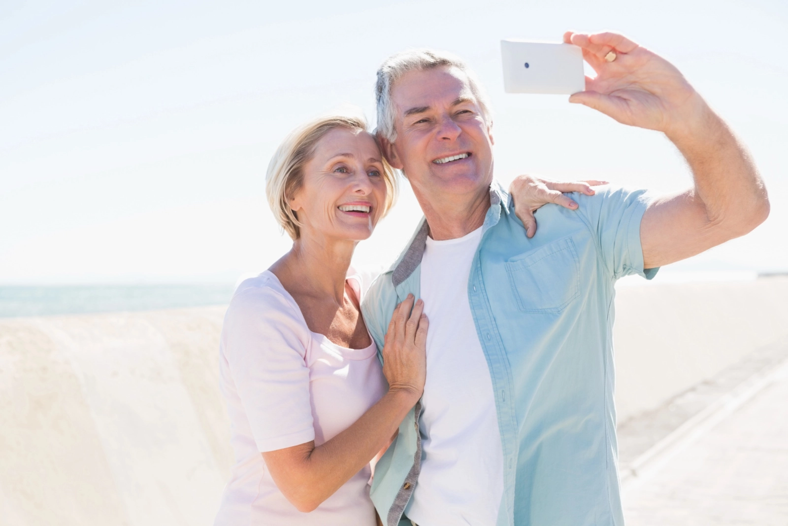A happy older couple taking a photo together outdoors
