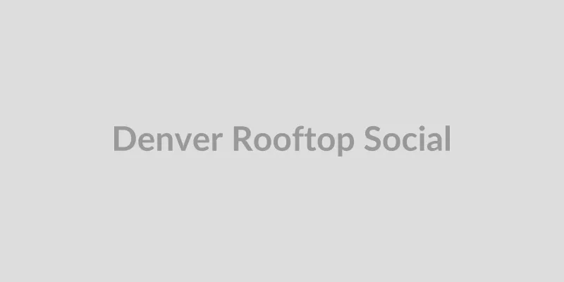 Group socializing on a rooftop bar with Denver skyline