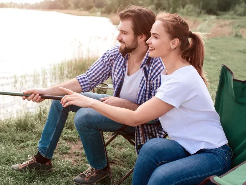 A couple sitting by a lake on a bright afternoon