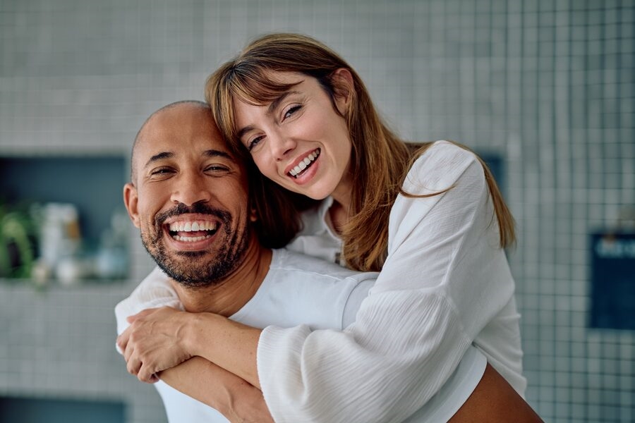 Couple laughing and embracing joyfully indoors