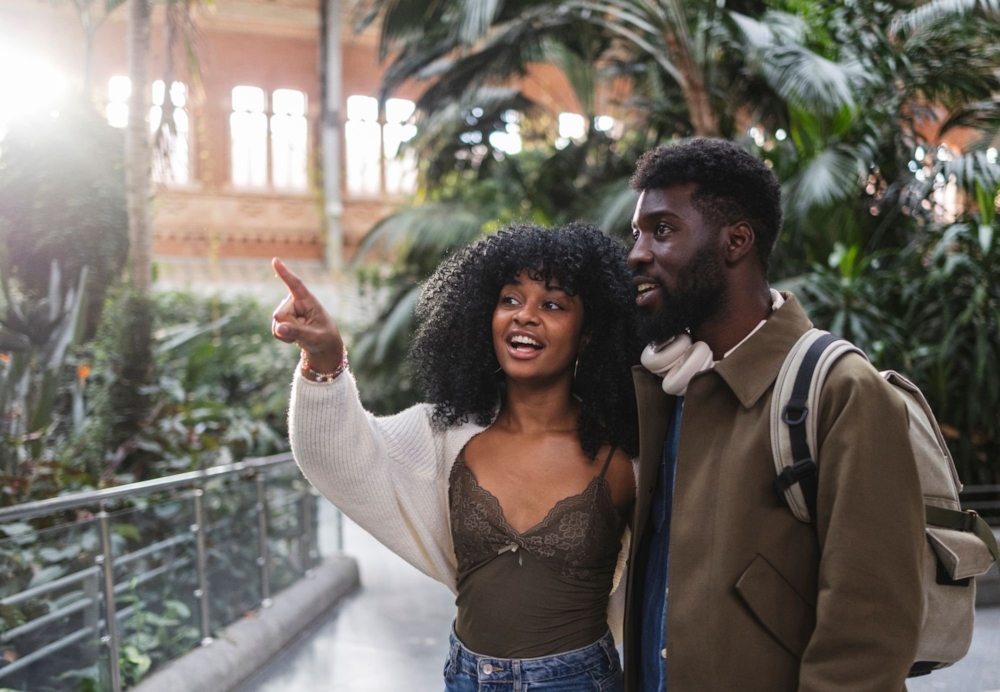 A woman pointing something out to a man as they explore a leafy botanical garden