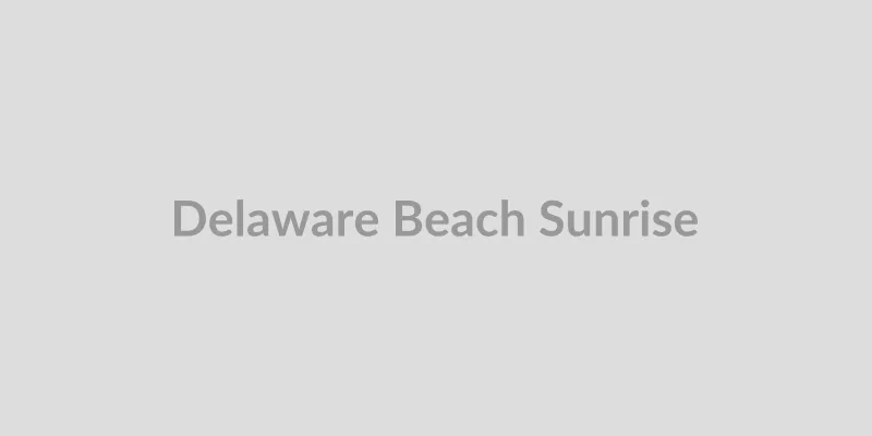 Couple walking on a Delaware beach at sunrise