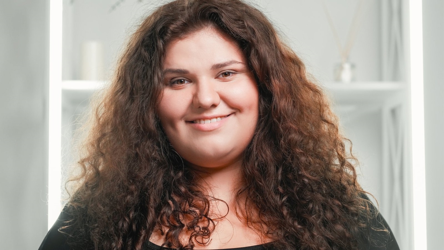 A woman smiling warmly in a close portrait at home