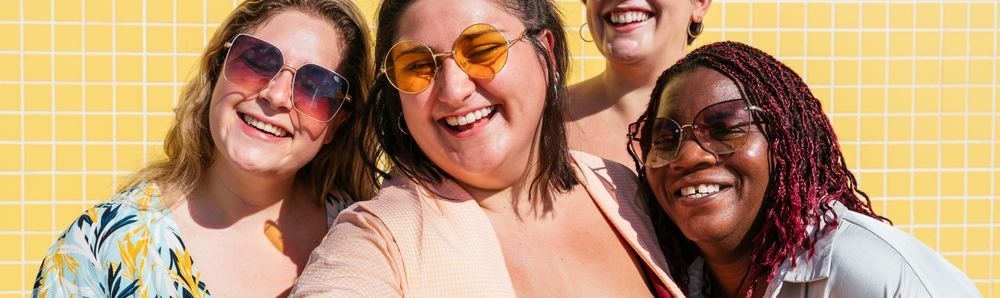 A group of chubby and curvy friends laughing together