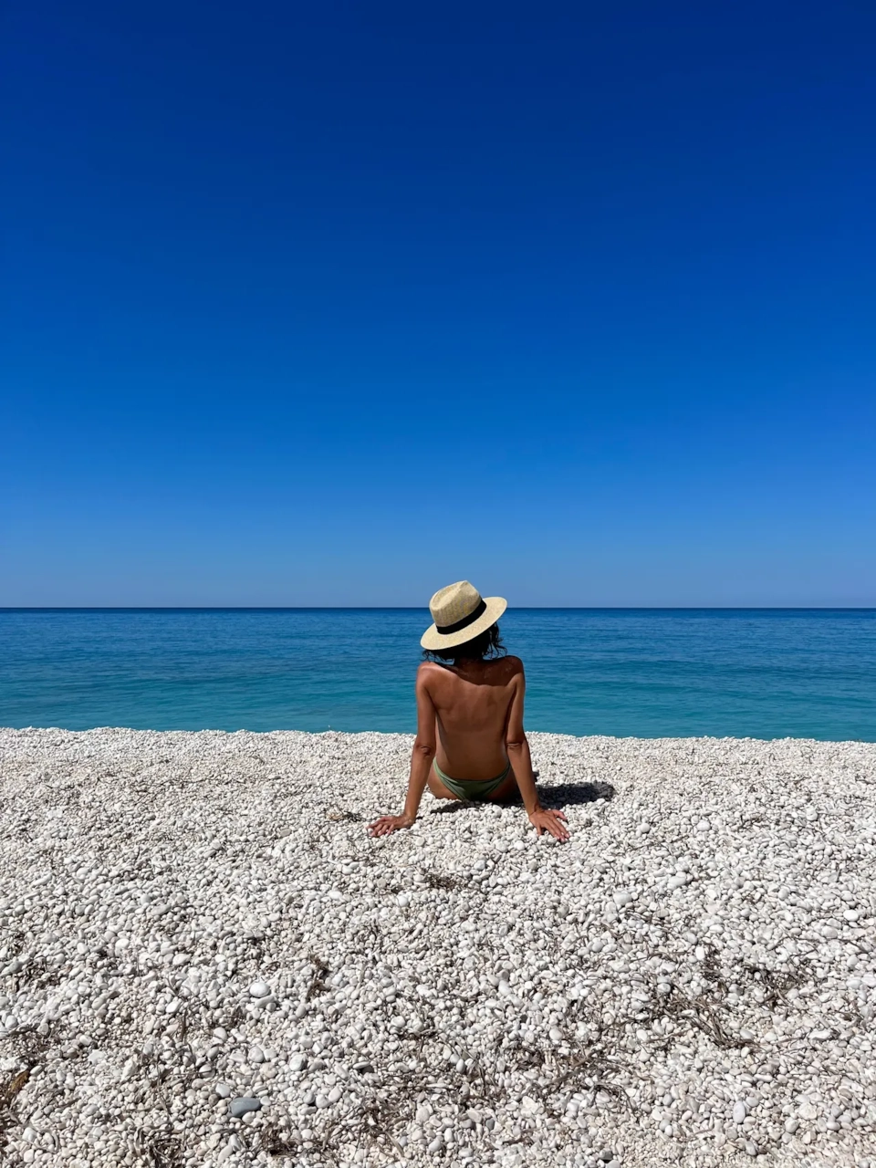 Illustrative stock photograph of an adult looking across a pebble beach