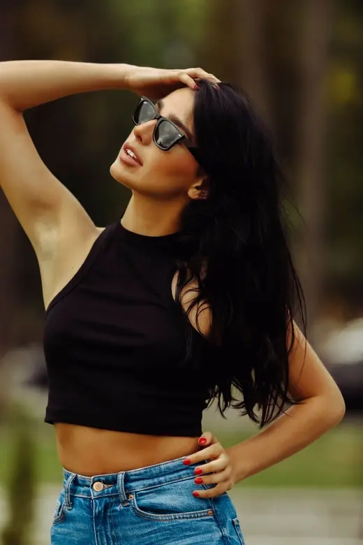 A woman in sunglasses photographed outdoors in summer light