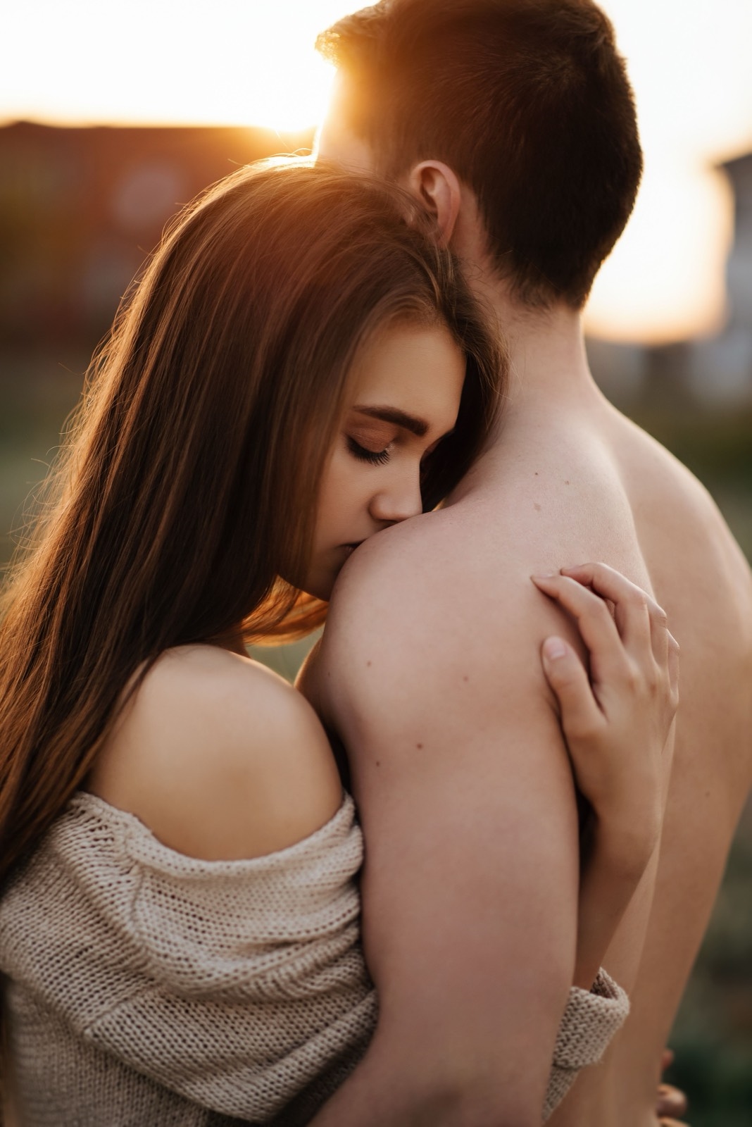 Illustrative stock photo of two adults in a close outdoor embrace at sunset. Does not depict real members.