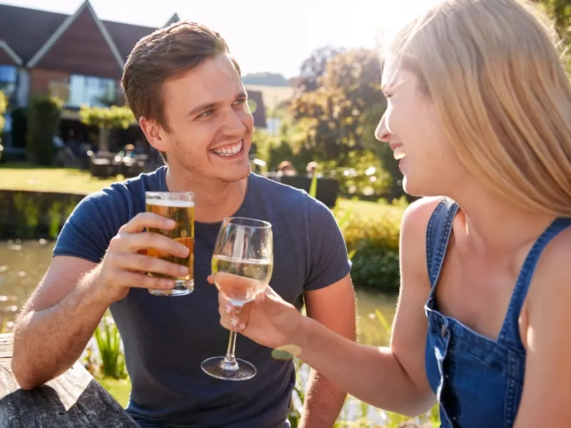 Two people talking over a drink in a pub garden