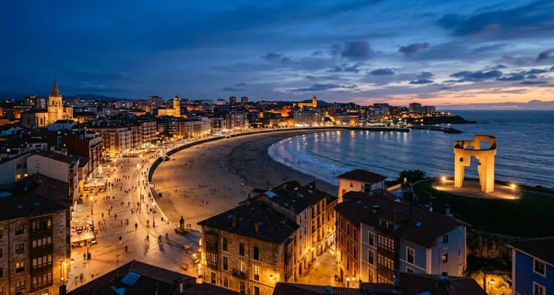 Vista aérea de Gijón al anochecer con la playa de San Lorenzo