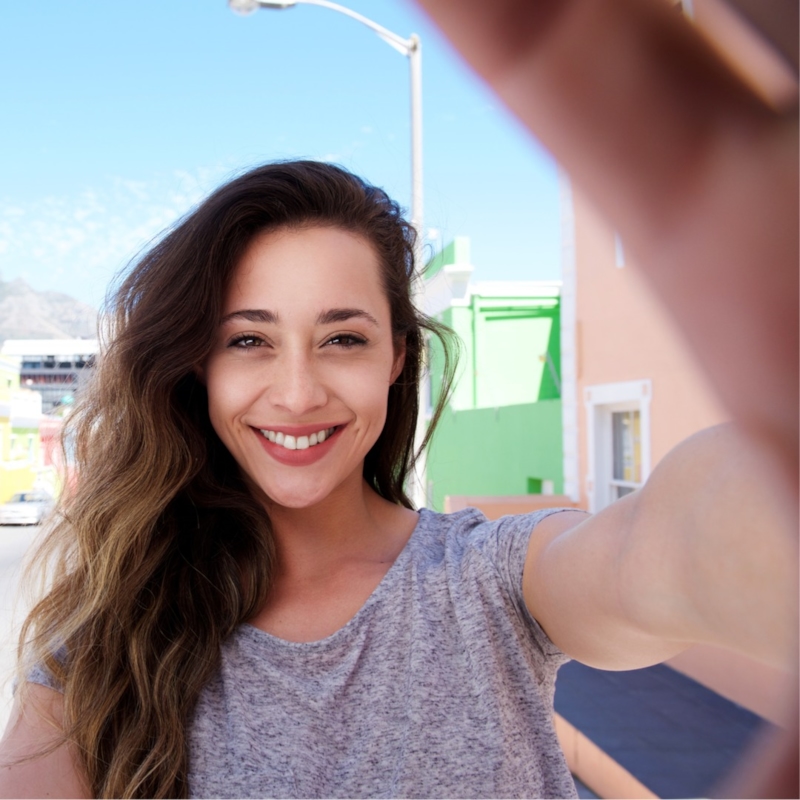 A woman smiling at her phone
