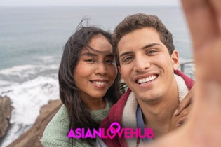 Two people smiling at their phones, matching and chatting on Asian Love Hub dating platform.