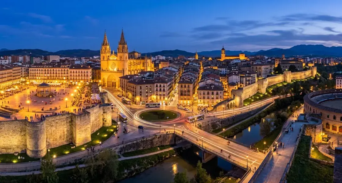Vista aérea de Pamplona al anochecer, con la ciudadela, la catedral y las murallas iluminadas