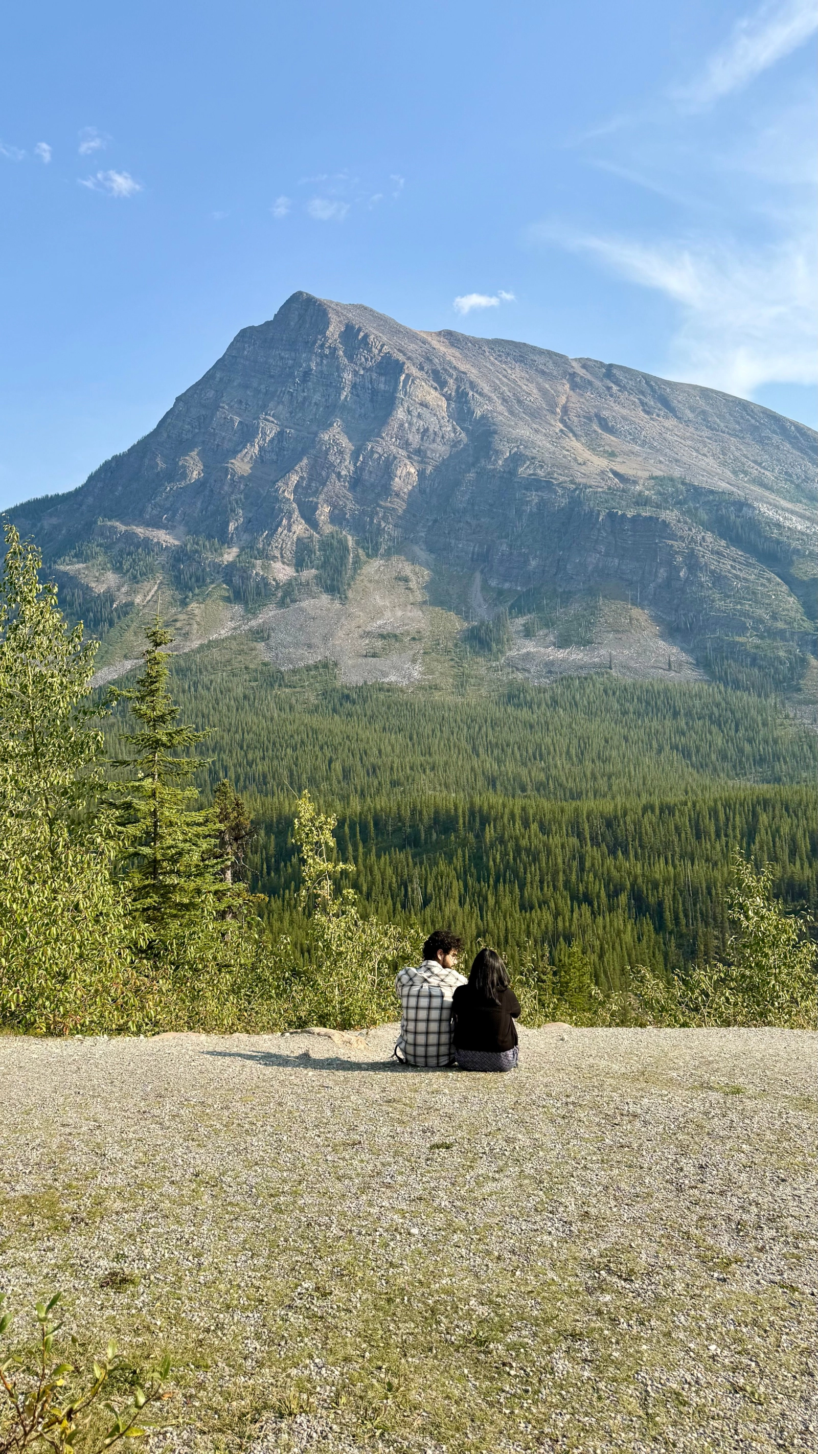 Person relaxing in a grassy meadow beneath a mountain
