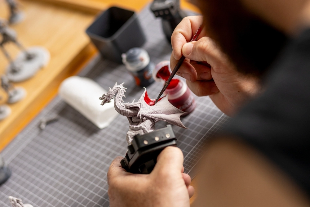 Miniature painter working on detailed game figures