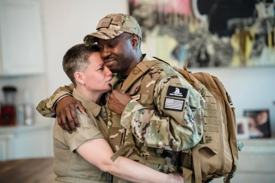 Illustrative photo, not an actual member. A couple embracing, one in military uniform.