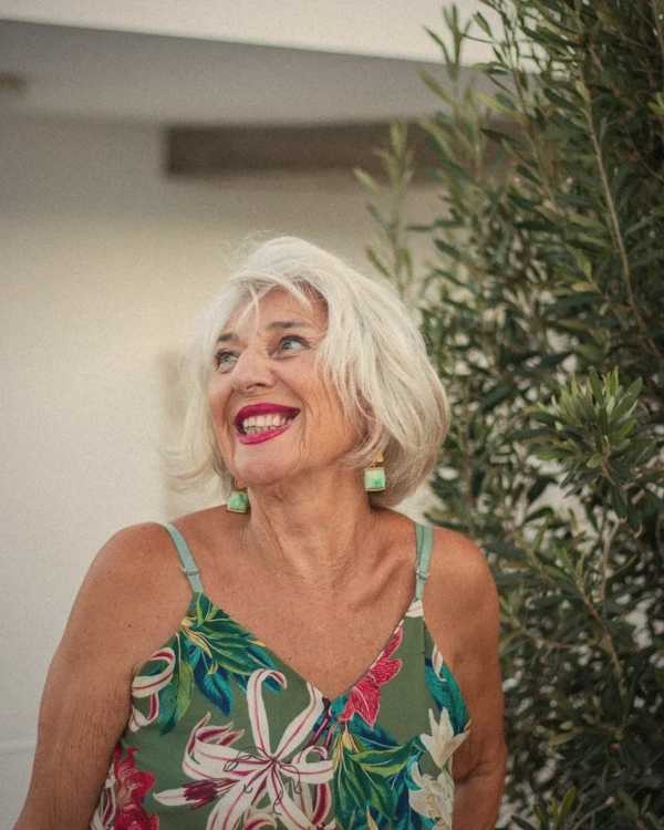 Smiling woman with white hair in a floral dress