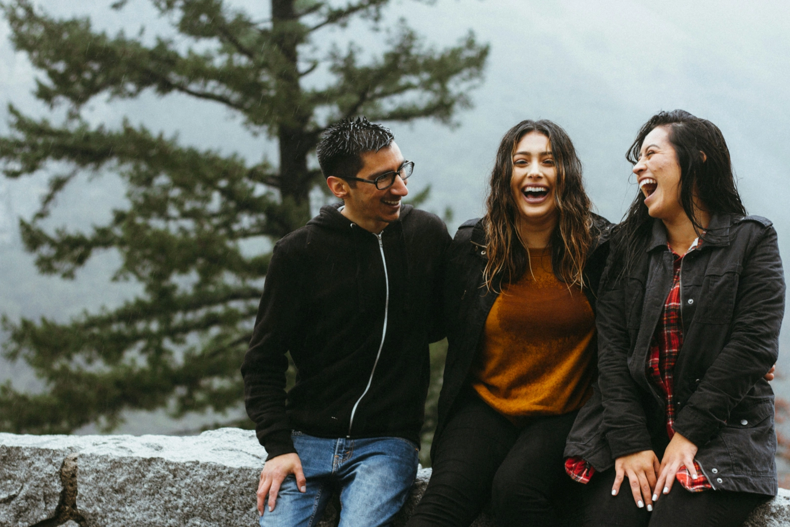 Tres personas riendo juntas al aire libre