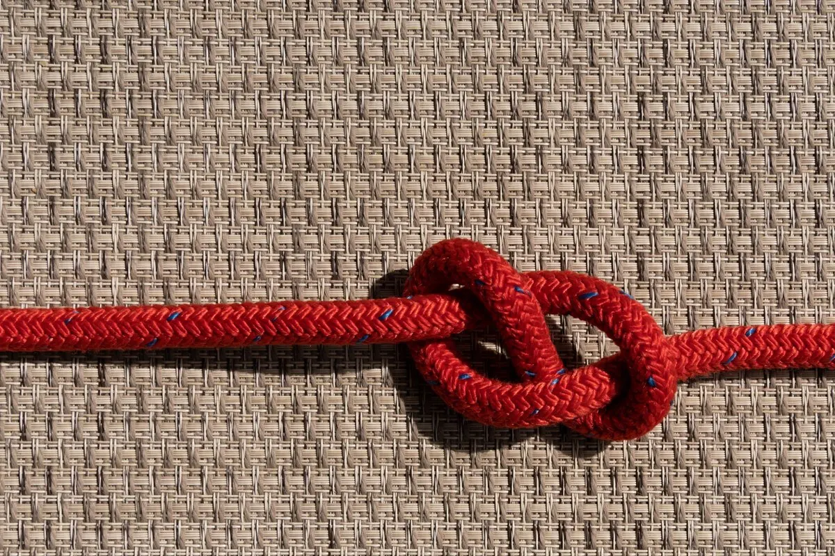 Red rope tied in a neat knot on a woven background