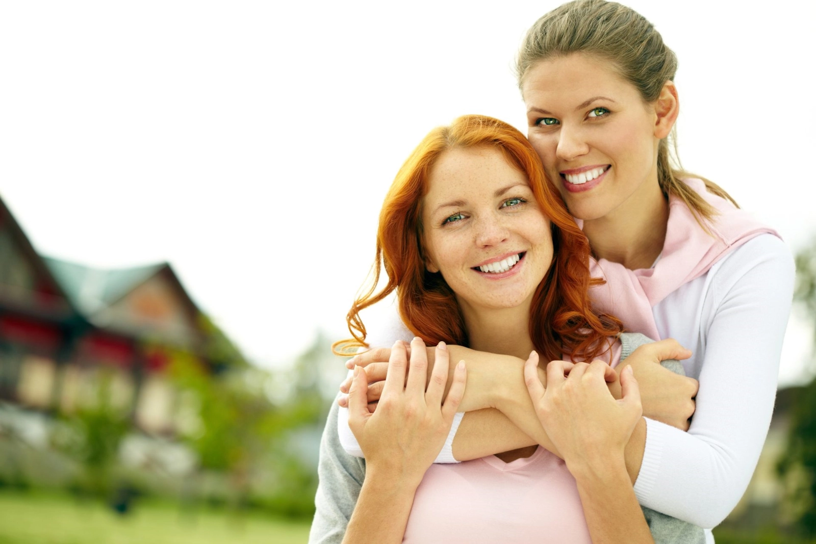 A woman hugging her partner from behind, both of them smiling