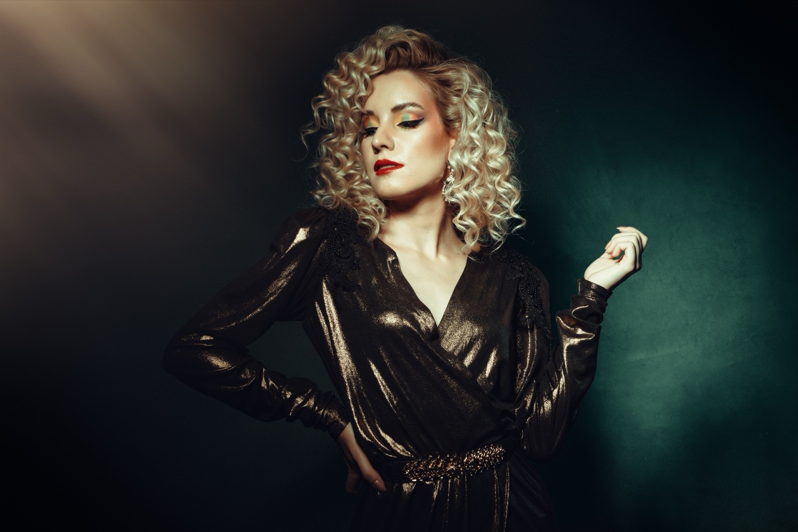 Illustrative stock photo of a woman in a metallic dress under studio light. Does not depict real members.