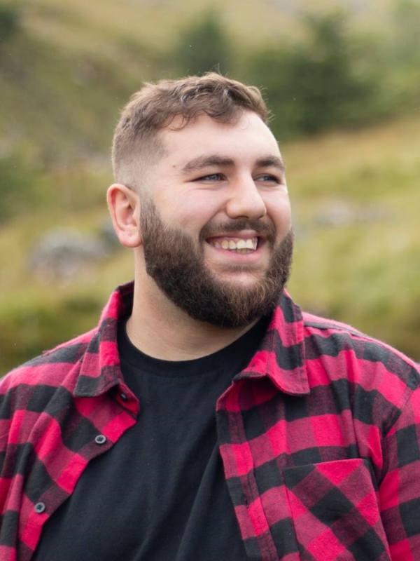 A chubby man smiling outdoors