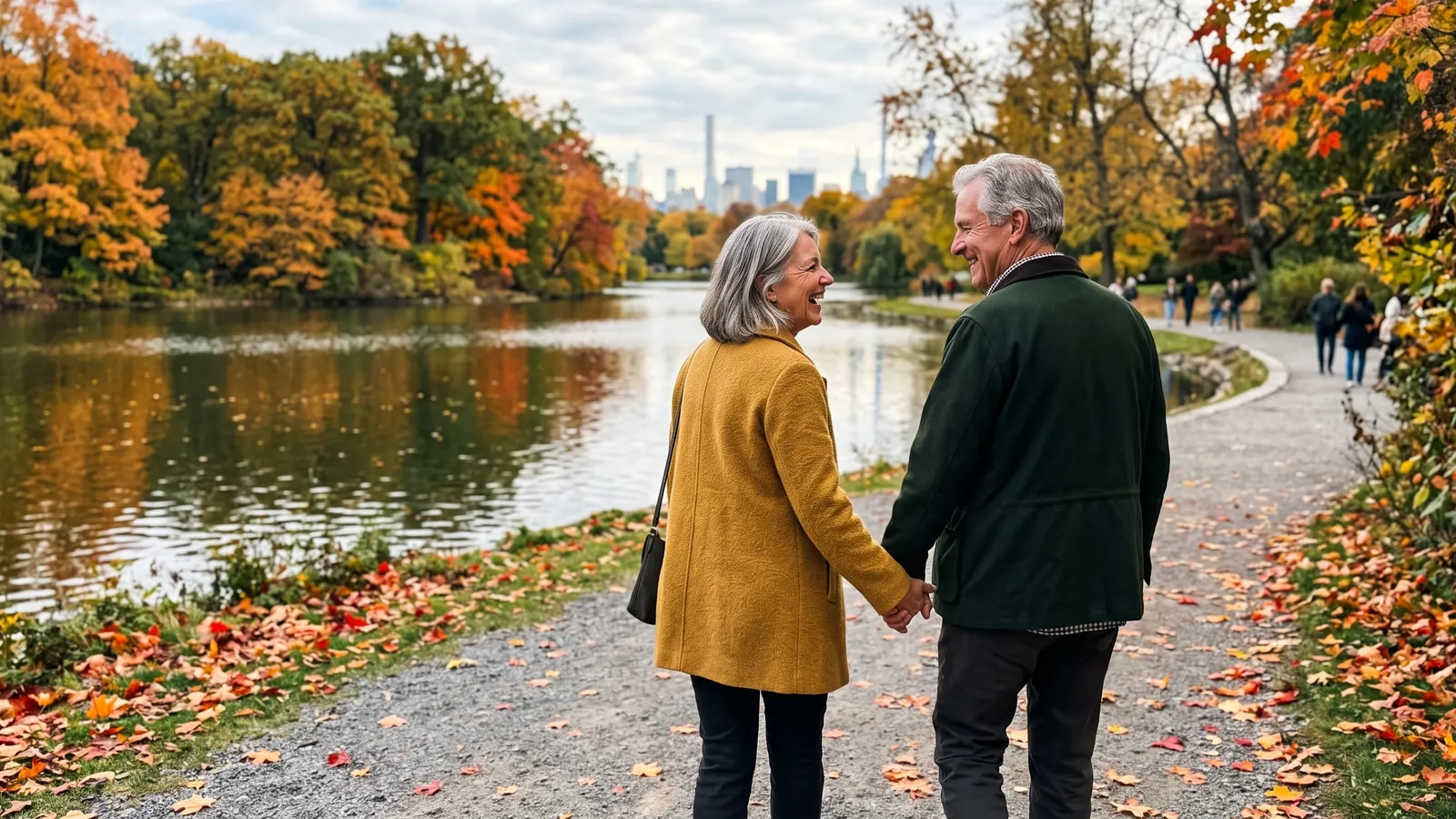 A couple in their late sixties walk hand in hand along a gravel path by a pond in a Toronto park, with red and orange autumn trees around them (AI-generated image)